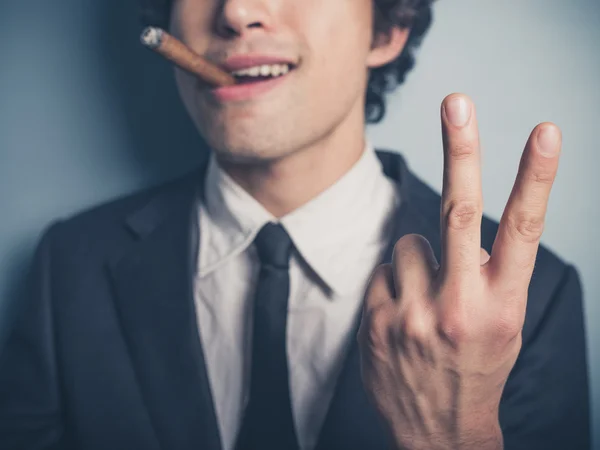 Joven hombre de negocios con cigarro mostrando gesto grosero — Foto de Stock