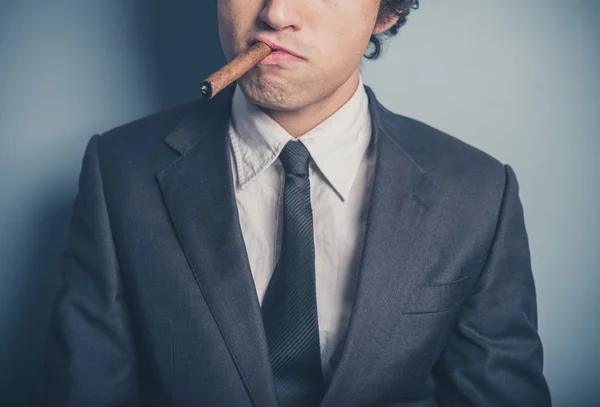 Young businessman smoking a cigar — Stock Photo, Image