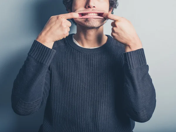 Jovem puxando caras bobas — Fotografia de Stock