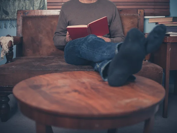 Mladý muž čte doma — Stock fotografie