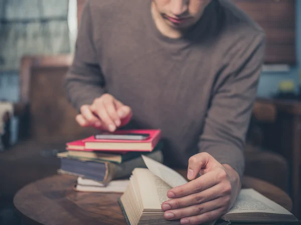 Homem estudando e usando telefone inteligente em casa — Fotografia de Stock