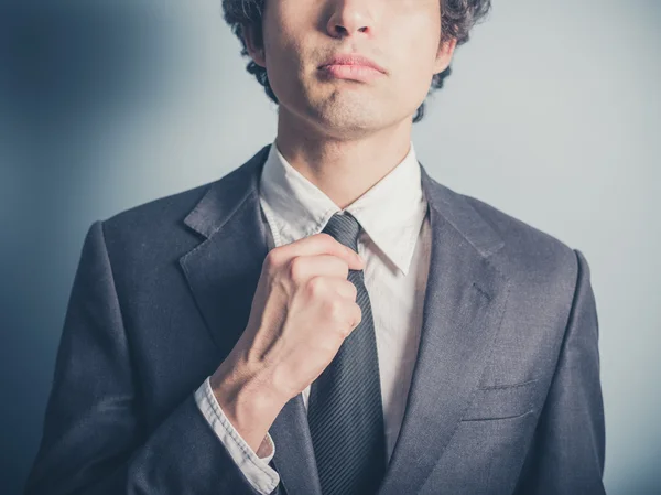 Junger Geschäftsmann justiert seine Krawatte — Stockfoto