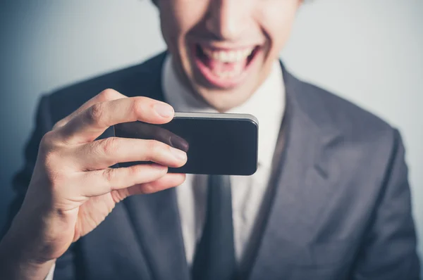 Zufriedener Geschäftsmann mit seinem Smartphone — Stockfoto