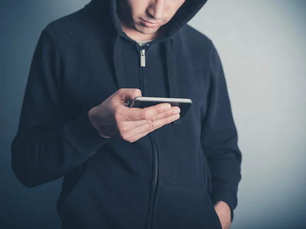 Hombre con capucha superior usando su teléfono inteligente — Foto de Stock