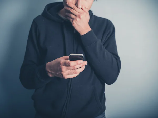 Chockad ung man använder smartphone — Stockfoto