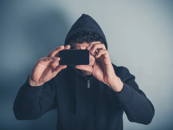 Man in hooded top taking photos — Stock Photo, Image