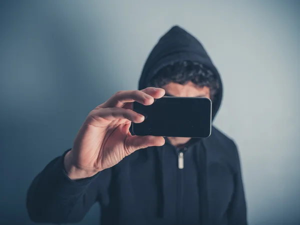 Man in hooded top taking photos — Stock Photo, Image