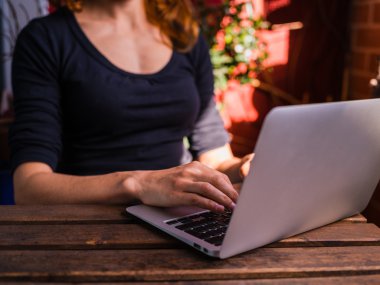 Balkonda onu laptop dışında kullanan kadın