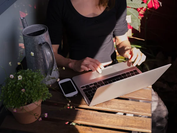 Γυναίκα χρησιμοποιώντας το laptop της έξω στο μπαλκόνι — Φωτογραφία Αρχείου