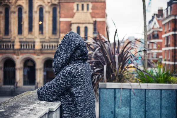 Persona in giacca incappucciata ammirando città — Foto Stock