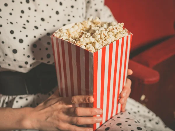 Junge Frau isst Popcorn im Kino — Stockfoto