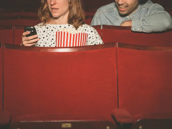 Frau benutzt ihr Handy im Theater — Stockfoto