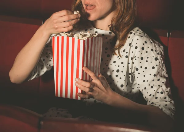 Mulher comendo pipoca e assistindo filme — Fotografia de Stock