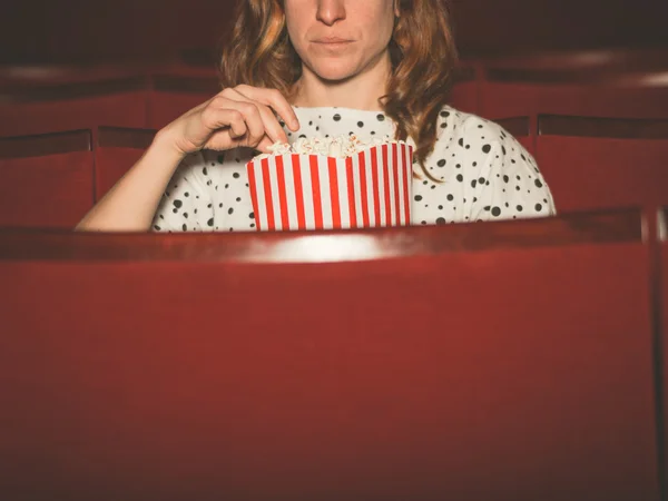 Mujer comiendo palomitas de maíz y viendo películas — Foto de Stock