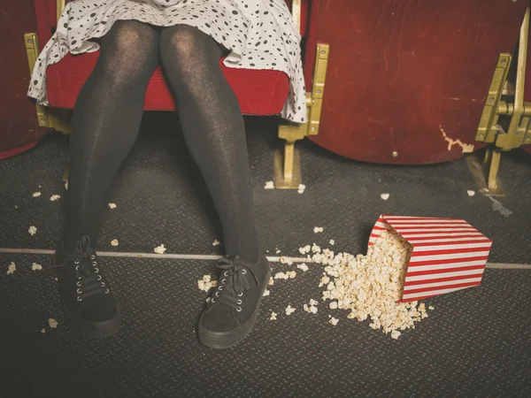 Donna in teatro con popcorn sul pavimento — Foto Stock