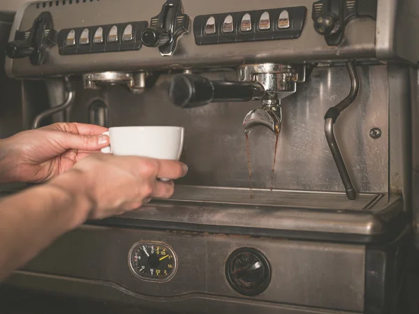 Handen plaatsen kopje onder koffiemachine — Stockfoto