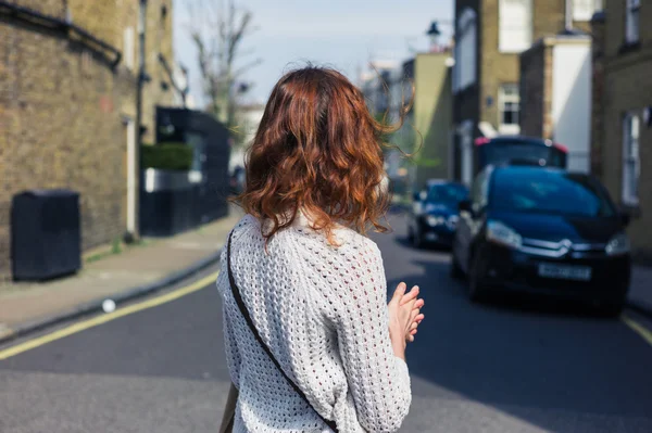 Vrouw wandelen in de straat met geparkeerde auto 's — Stockfoto