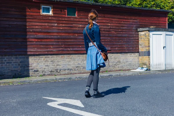 Woman standing outside by big arrow — Stock Photo, Image