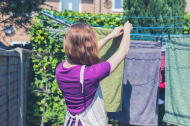 Kadın bahçede çamaşır asılı