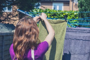 Kadın bahçede çamaşır asılı