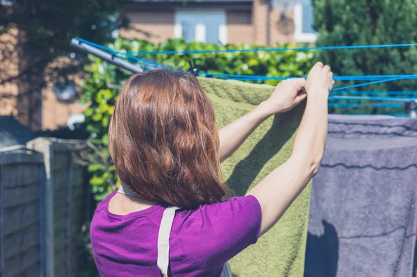 Frau hängt ihre Wäsche im Garten auf — Stockfoto