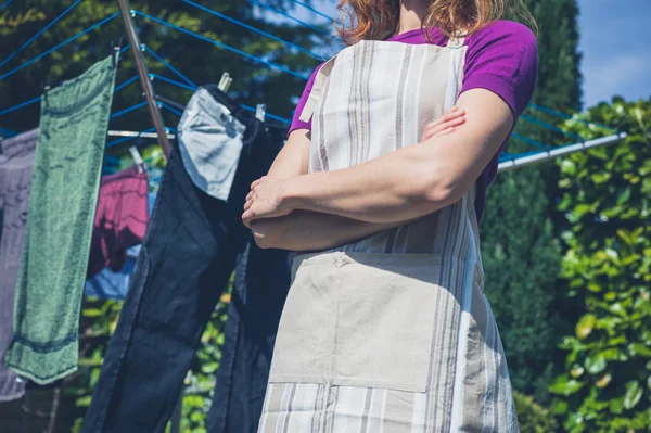 Femme en tablier debout près de la ligne de vêtements — Photo