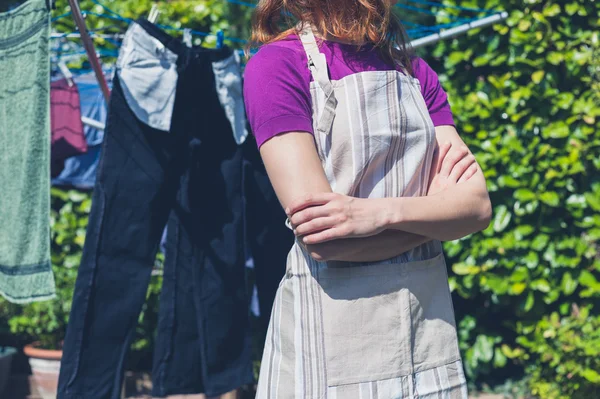 Frau in Schürze steht an Wäscheleine — Stockfoto