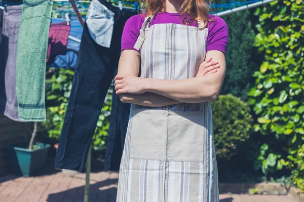 Femme en tablier debout près de la ligne de vêtements — Photo