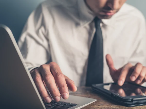 Geschäftsmann mit Laptop und Tablet — Stockfoto