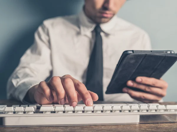 Podnikatel pomocí tabletu a psaní na klávesnici — Stock fotografie