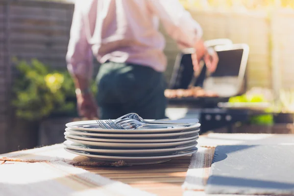 Plates on a table outside with man in background — Stock Photo, Image