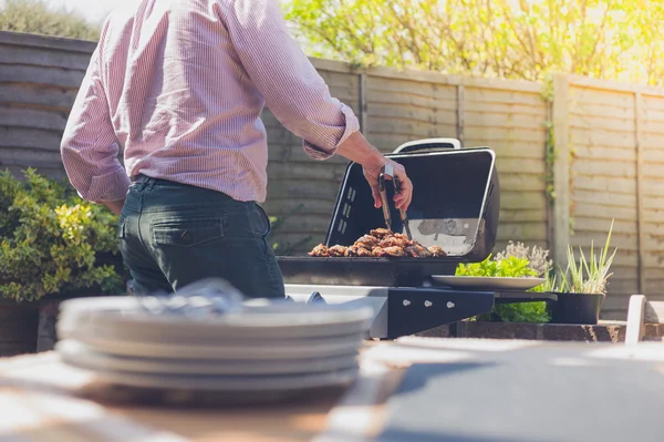 Plater på et bord utenfor med en mann i bakgrunnen – stockfoto