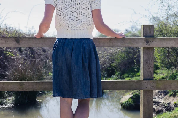 Kobieta stojąc na małych wiejskich most — Zdjęcie stockowe