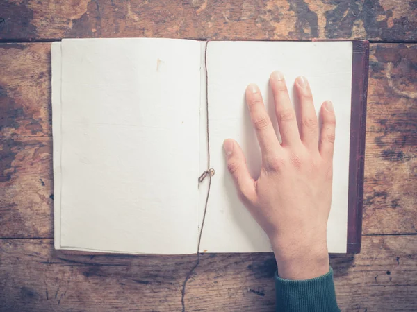 Hand en Kladblok op een houten tafel — Stockfoto