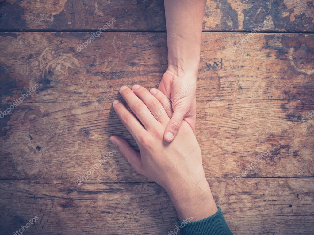 Man and woman holding hands at a table — Stock Photo © lofilolo #74313117