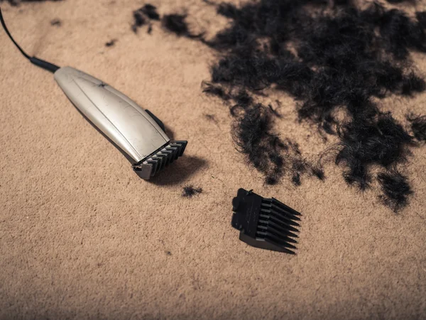 Cortadores de cabelo rodeados de cabelo — Fotografia de Stock