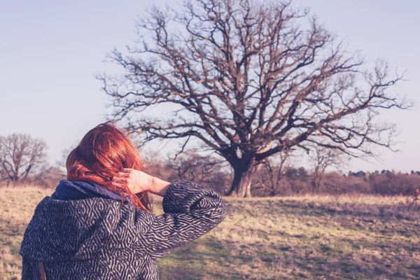 Giovane donna che cammina per la campagna in inverno — Foto Stock