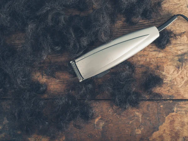 Ahşap masa üzerinde saç kesme makineleri — Stok fotoğraf