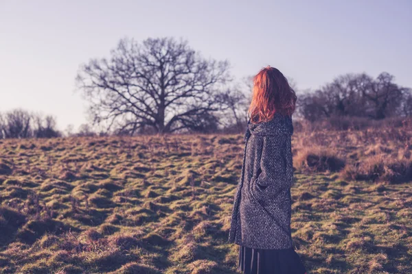 Ung kvinna går på landsbygden i vinter — Stockfoto