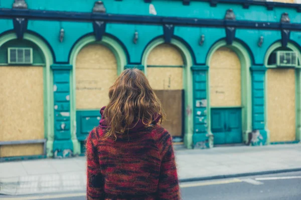 Mujer mirando el edificio tapiado —  Fotos de Stock