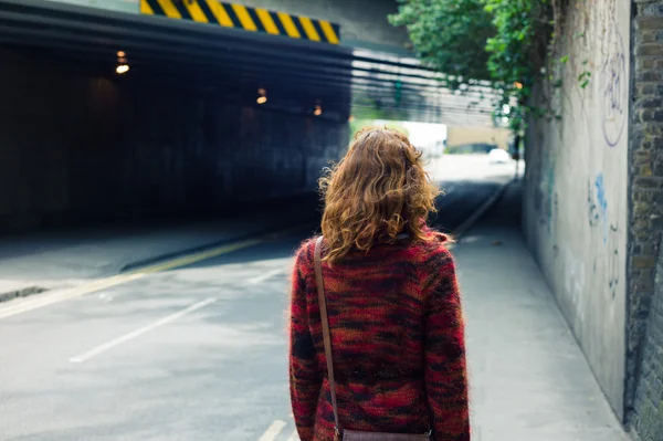 Mulher andando na rua perto de uma passagem subterrânea — Fotografia de Stock