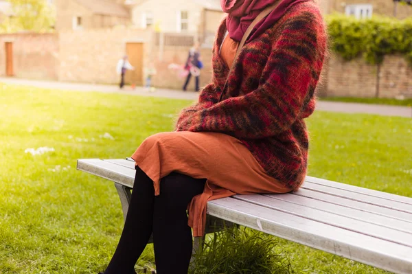 Mujer descansando en un banco en un parque — Foto de Stock