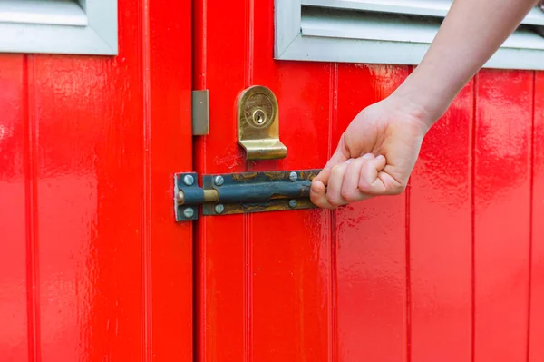 Hand opening little red door — Stock Photo, Image