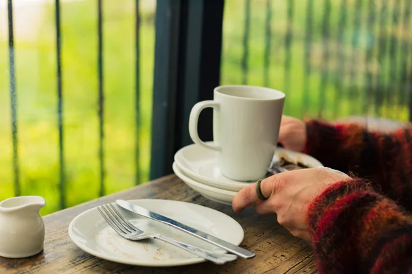 Woman with empty plates and mug — Stock Photo, Image