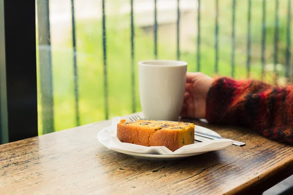 Thee en cake door het venster — Stockfoto