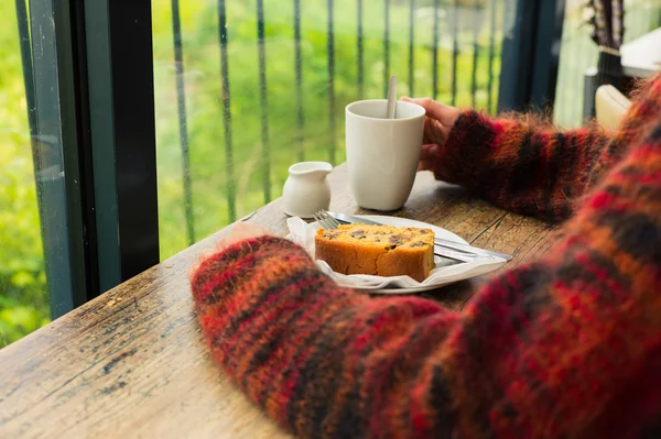 Mujer bebiendo té y tomando tarta — Foto de Stock