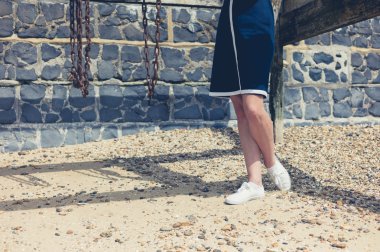 Eski ahşap yapı ile sahilde duran genç kadın