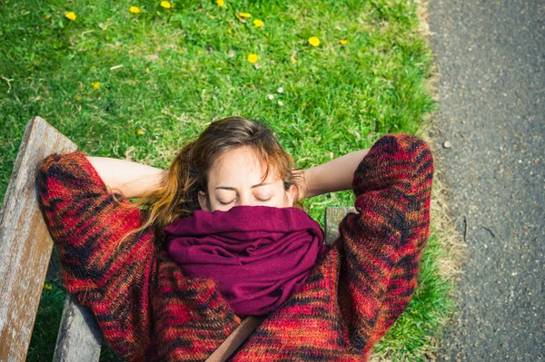 Женщина спит на скамейке в парке — стоковое фото