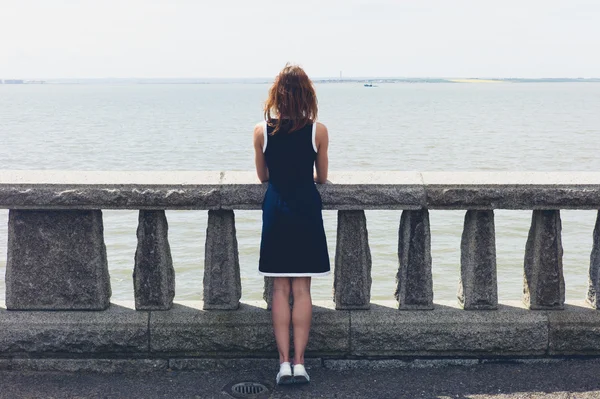 Mladá žena obdivuje moře od promenády — Stock fotografie