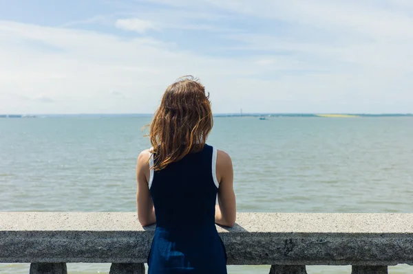 年轻女人欣赏海从长廊 — 图库照片